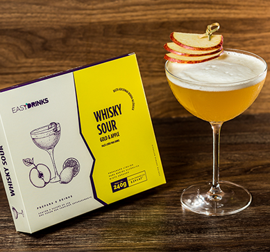 Item Easy Drinks - Whisky Sour  Gold e Apple ao lado de uma taça sobre a mesa.