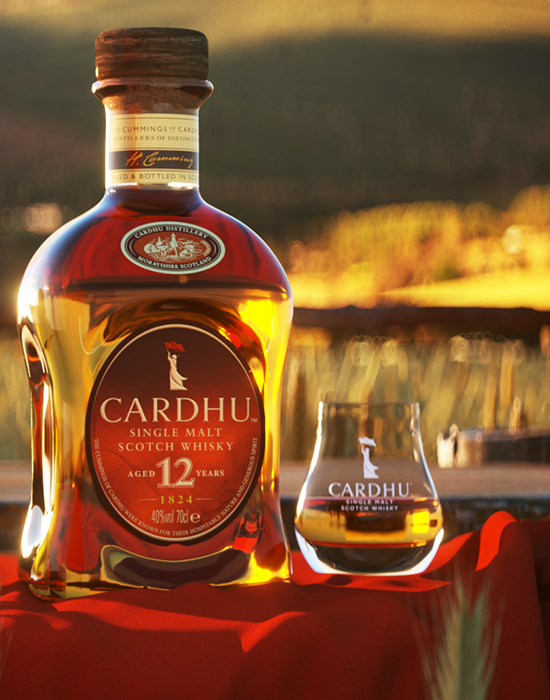 Garrafa do whisky Cardhu sobre a mesa e ao lado de um copo baixo.