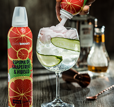 Item Easy Drinks - Espuma de Grapefruit com Hibisco ao lado de uma taça sobre a mesa.