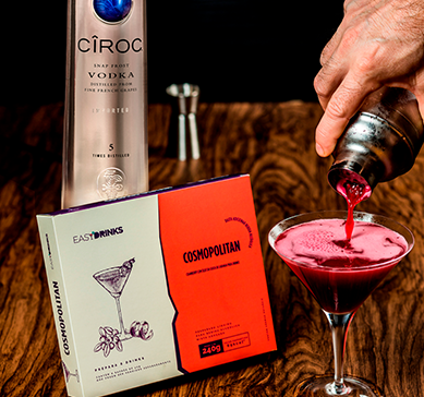 Item Easy Drink - Cosmopolitan com uma taça, coqueteleira e garrafa de Cîroc sobre a mesa.