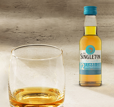 Mini Singleton 50ml ao lado de um copo com whisky 