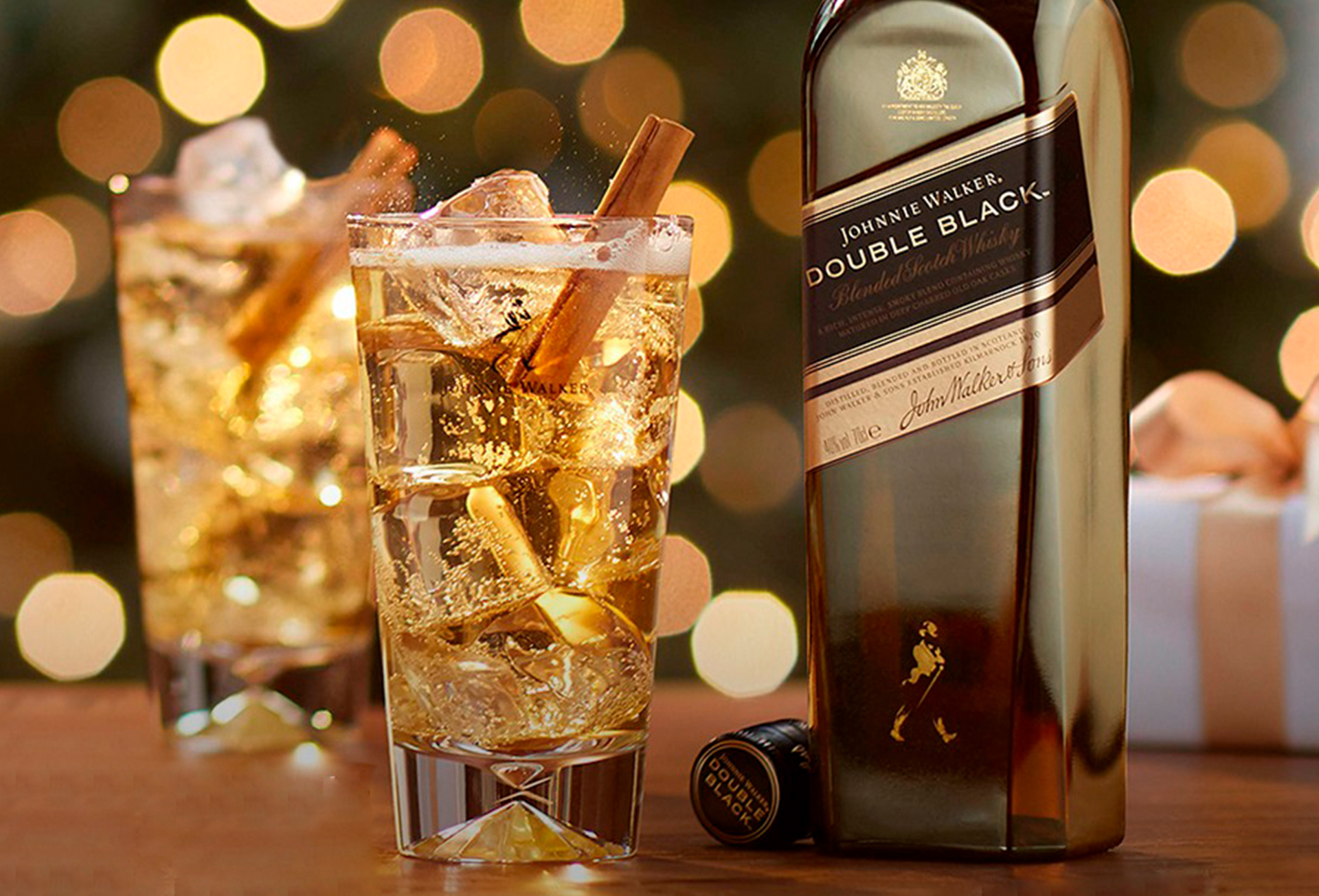 Garrafa Johnnie Walker Double Black 1L com um copo alto e whisky.