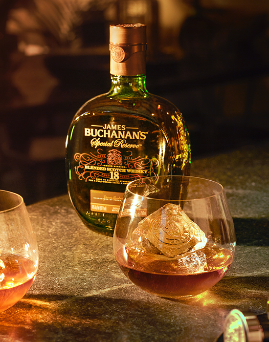 Garrafa do whisky Buchanan's 18 anos ao lado de copo com dose