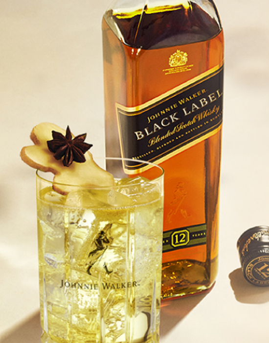 Garrafa Johnnie Walker Black Label com um copo com gelo, whisky e uma fatia de limão Tahiti
