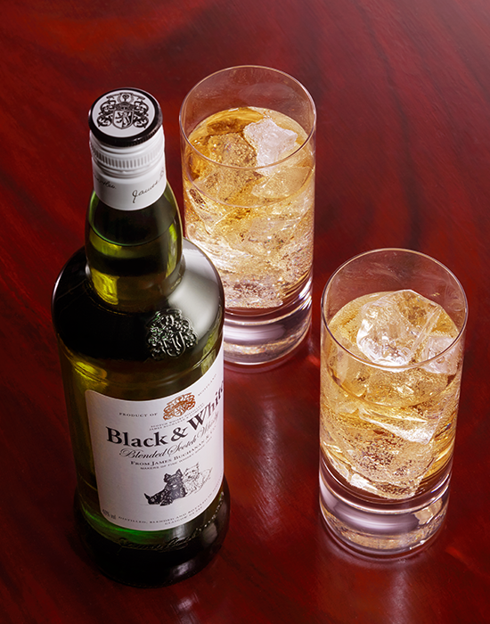 Garrafa Black & White com dois copos com gelo e whisky